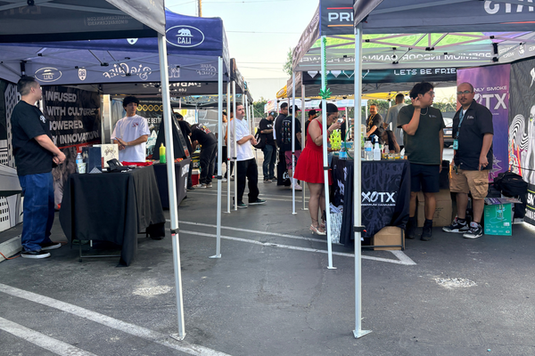 Vendor booths and attendees gathered at an outdoor cannabis community event during a 714 Day celebration in Orange County.