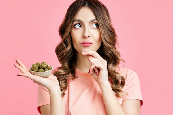 Woman holding a bowl of raw cannabis flower, illustrating whether you can eat weed raw and what science says about its effects.