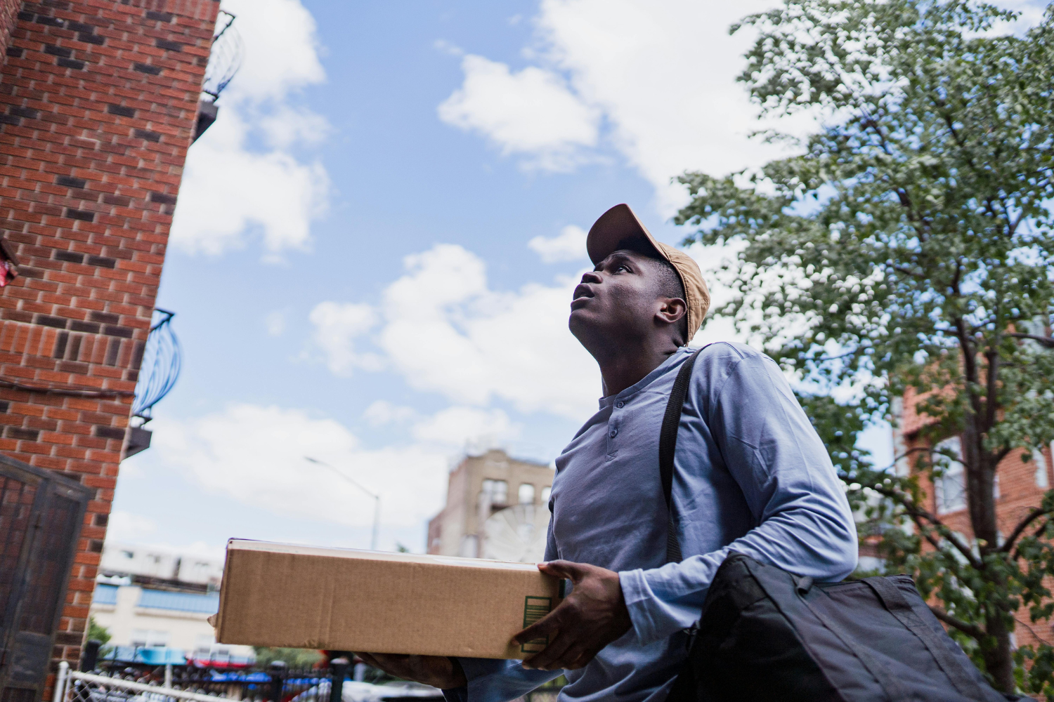 A courier navigates an urban residential area to safely drop off a secure package to a verified customer.