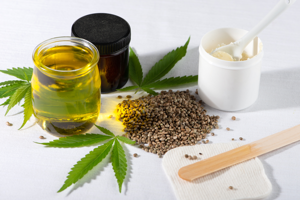 CBN vs CBD hemp products including oil, cream, seeds, and cannabis leaves on white background