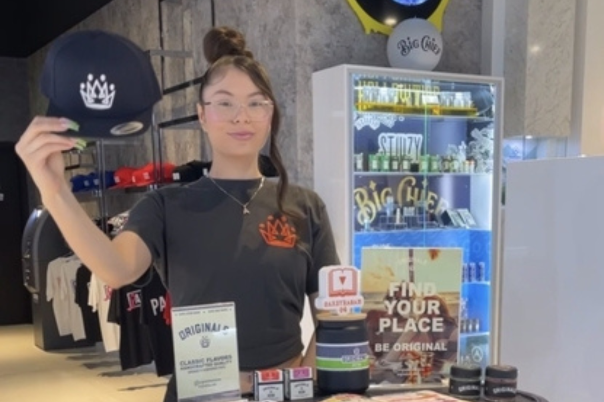 Packs Club team member standing behind a cannabis retail counter with products on display.