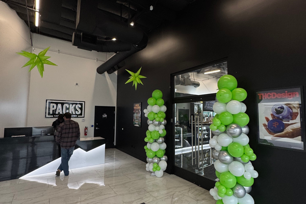 PACKS Club dispensary entrance decorated with green and white balloons for National Weed Day deals.